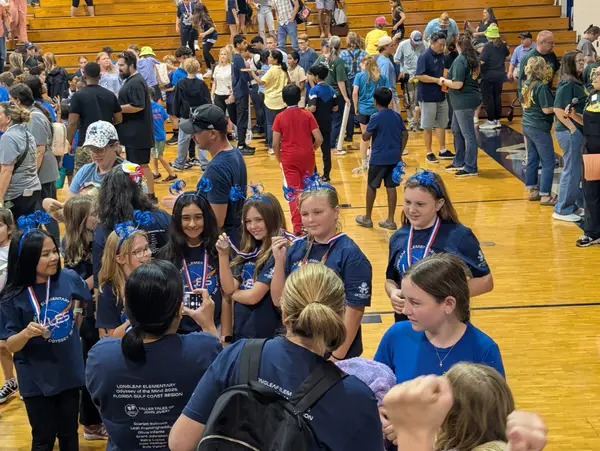 Team celebrating with medals in gymnasium